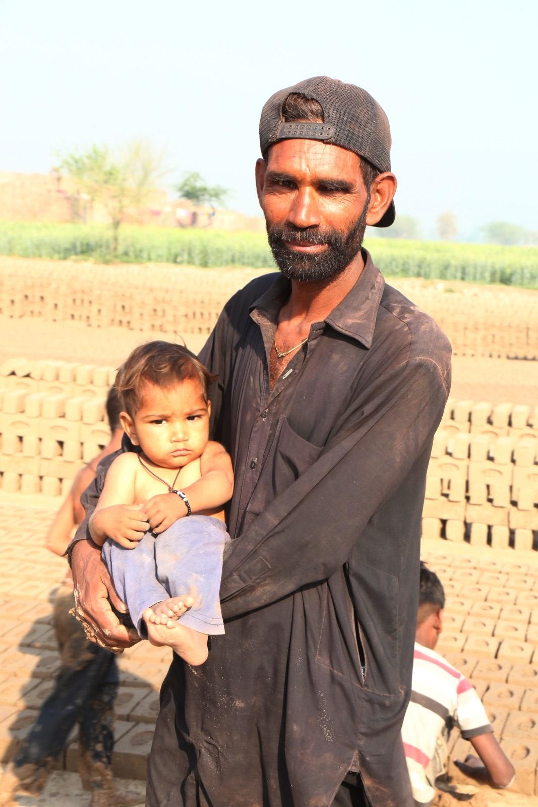 A father holding his toddler at the kiln